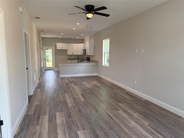 kitchen featuring kitchen peninsula, wood-type flooring, white cabinetry, and plenty of natural light