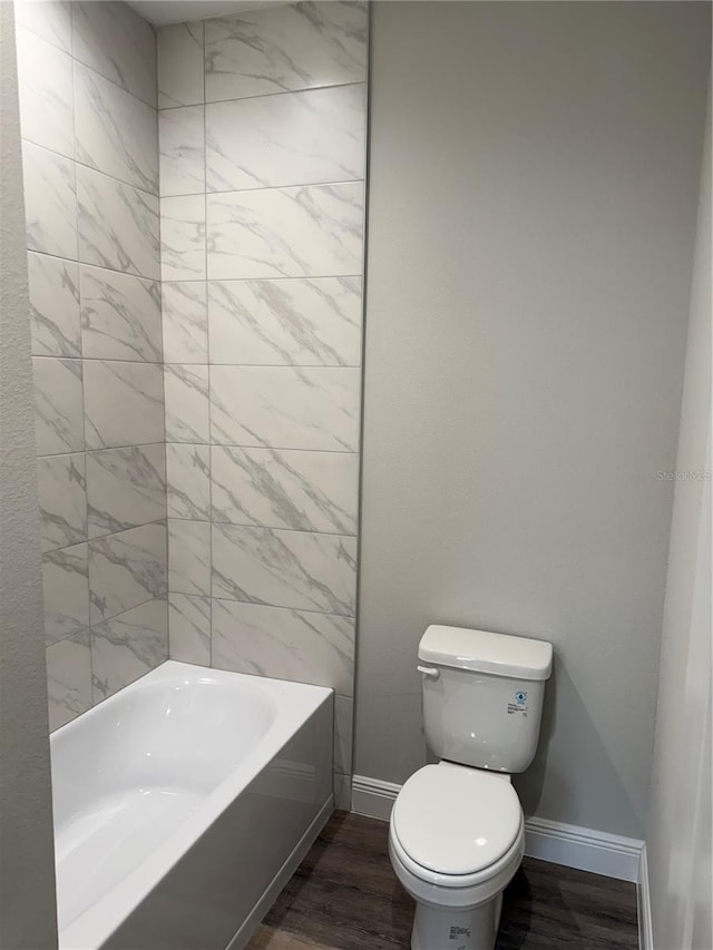 bathroom featuring hardwood / wood-style flooring, shower / washtub combination, and toilet