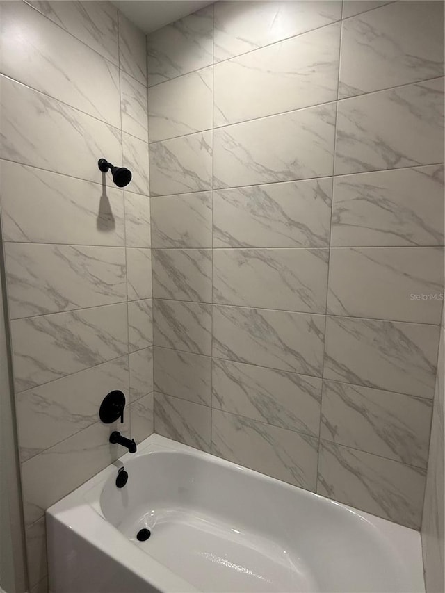 bathroom featuring tiled shower / bath