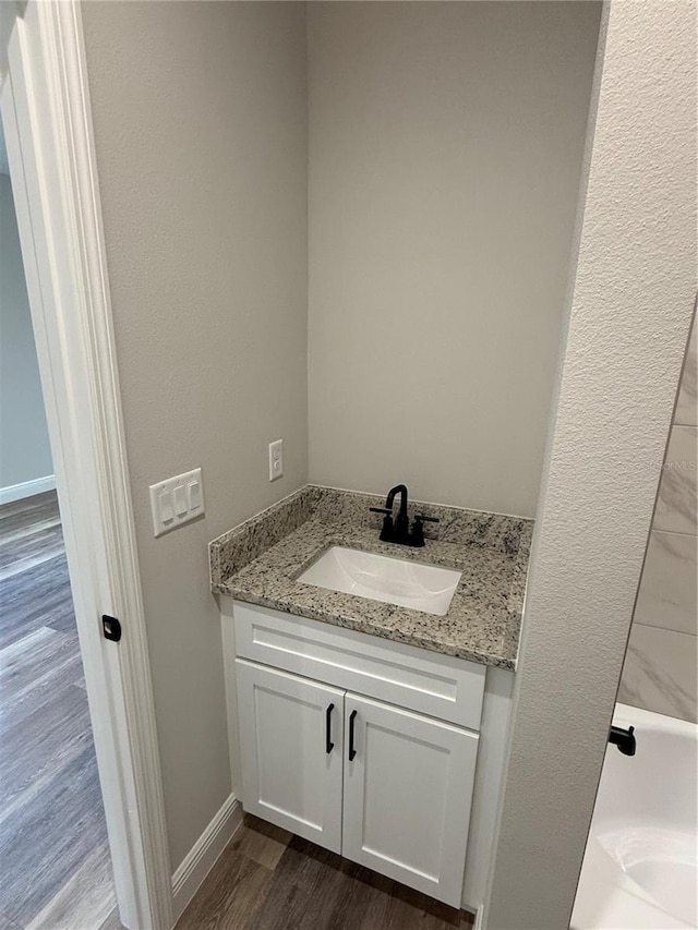 bathroom featuring a bath, vanity, and hardwood / wood-style flooring