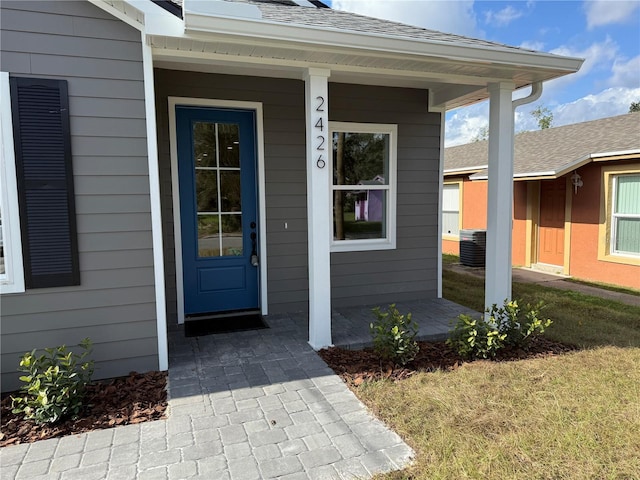 property entrance featuring covered porch and a yard