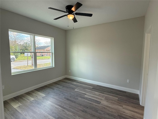 empty room with ceiling fan and dark hardwood / wood-style flooring