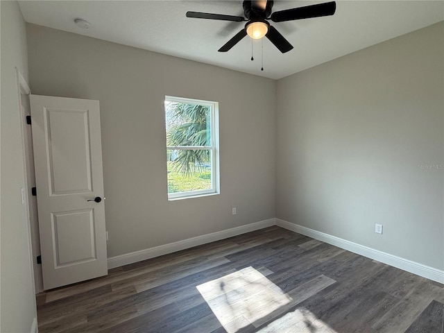 empty room featuring ceiling fan and dark hardwood / wood-style flooring