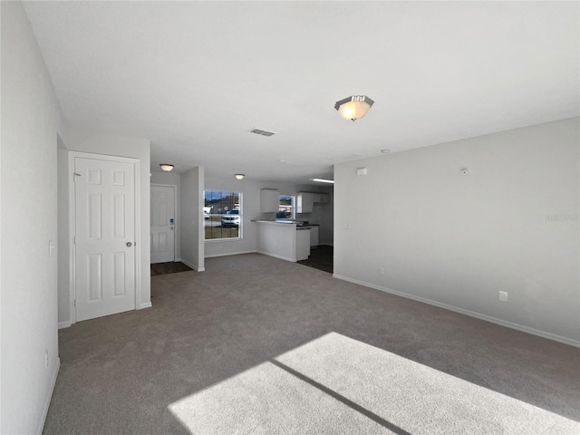 unfurnished living room with dark colored carpet