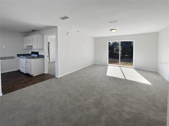 unfurnished living room with carpet flooring and a textured ceiling