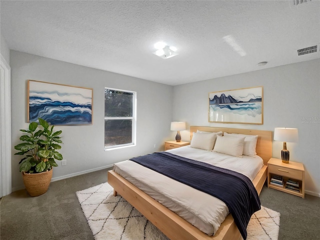 bedroom featuring a textured ceiling and dark carpet