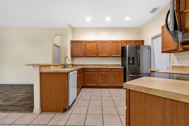 kitchen with kitchen peninsula, sink, dishwasher, stainless steel fridge with ice dispenser, and light tile patterned flooring