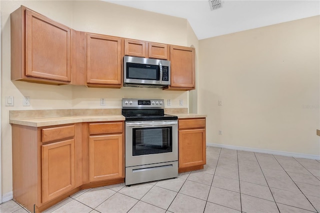 kitchen featuring light tile patterned flooring and appliances with stainless steel finishes