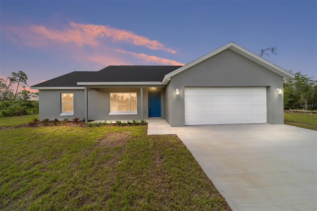 ranch-style house featuring a yard and a garage