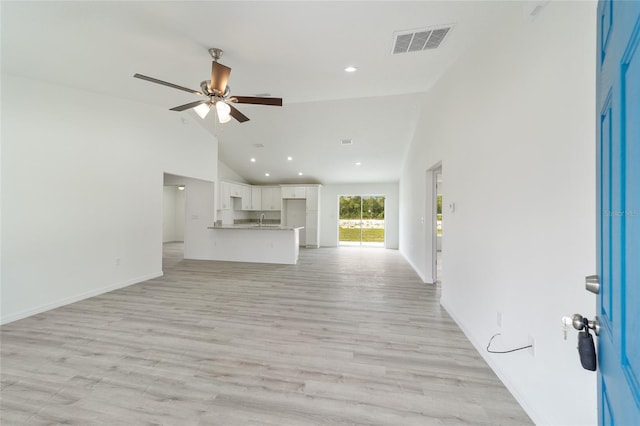 unfurnished living room with high vaulted ceiling, light hardwood / wood-style flooring, ceiling fan, and sink