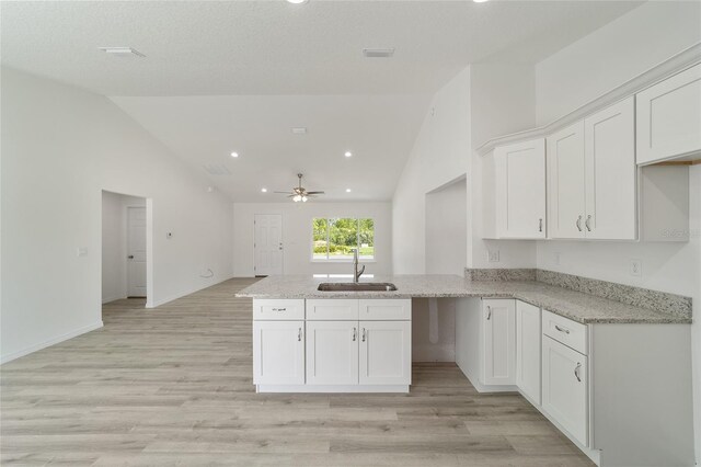 kitchen with ceiling fan, white cabinetry, and kitchen peninsula