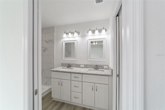 bathroom featuring hardwood / wood-style floors, vanity, and a textured ceiling