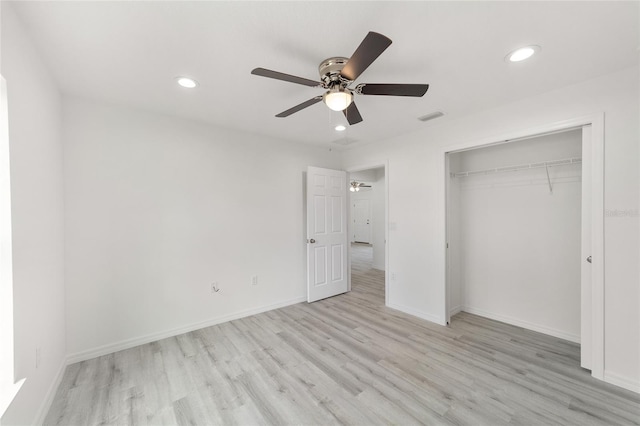 unfurnished bedroom with ceiling fan, light wood-type flooring, and a closet