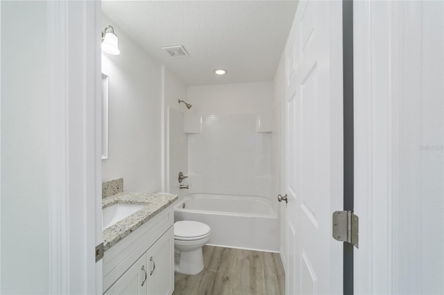 full bathroom with shower / bathtub combination, vanity, a textured ceiling, wood-type flooring, and toilet