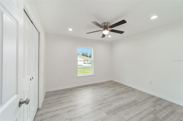 unfurnished bedroom with ceiling fan, light hardwood / wood-style flooring, and a closet