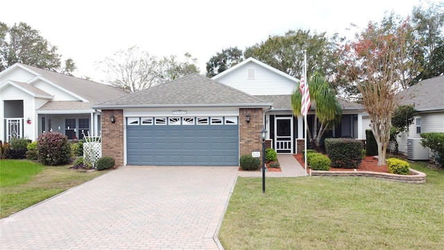 ranch-style home with a garage, central air condition unit, and a front yard