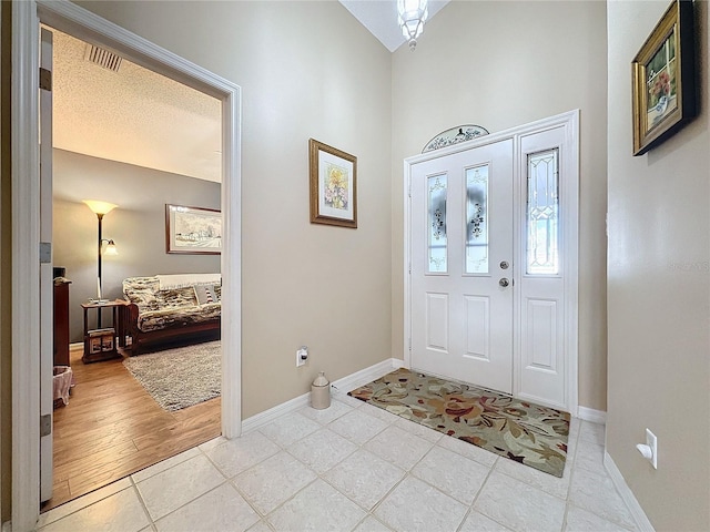 tiled entrance foyer featuring a textured ceiling