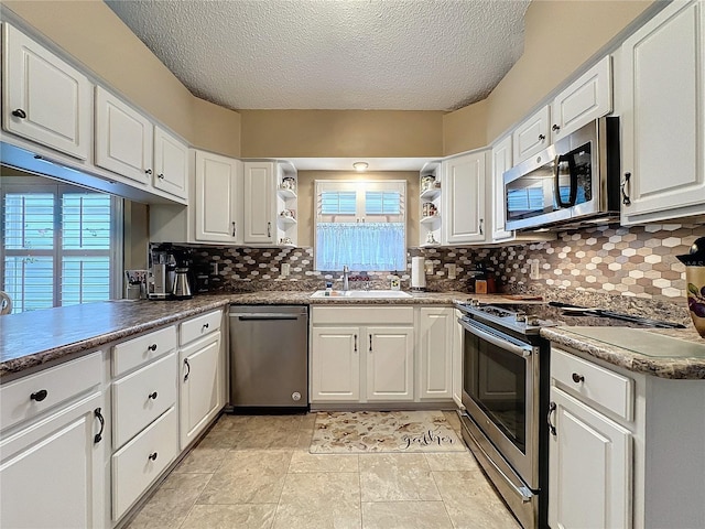 kitchen featuring appliances with stainless steel finishes, white cabinetry, and sink