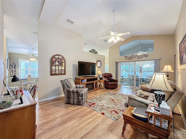 living room featuring ceiling fan, light hardwood / wood-style flooring, a healthy amount of sunlight, and lofted ceiling