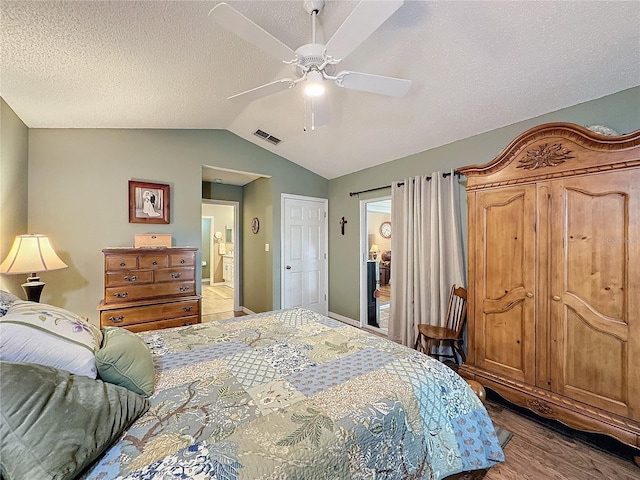 bedroom with hardwood / wood-style floors, a textured ceiling, ceiling fan, and lofted ceiling