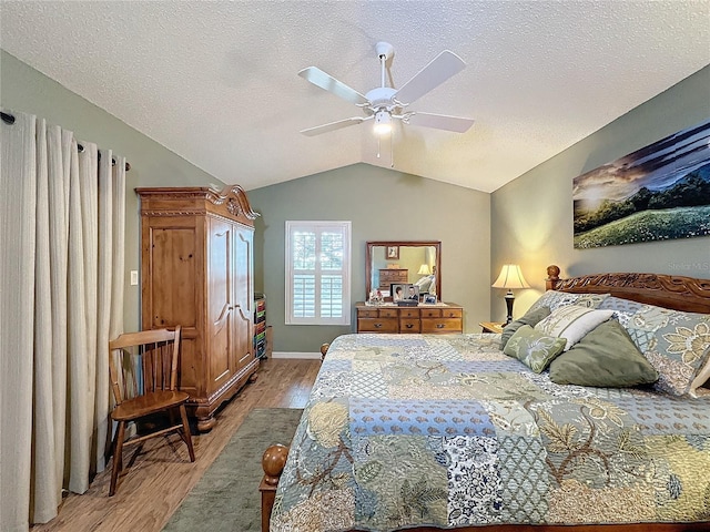 bedroom featuring a textured ceiling, ceiling fan, light hardwood / wood-style flooring, and lofted ceiling