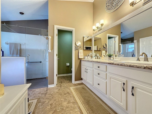 bathroom featuring vanity, a shower with door, and lofted ceiling