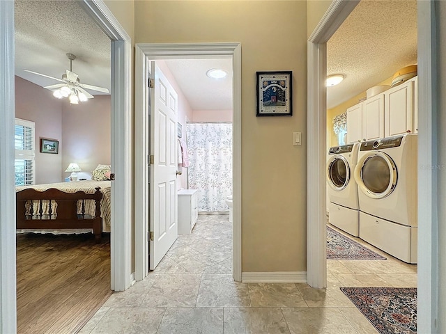 laundry room with cabinets, a textured ceiling, ceiling fan, and washing machine and clothes dryer