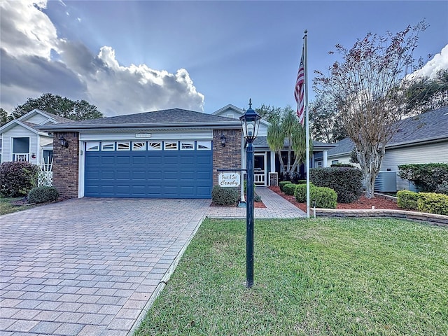 view of front of property featuring a front yard, a garage, and central air condition unit