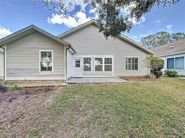 rear view of property featuring a patio and a lawn