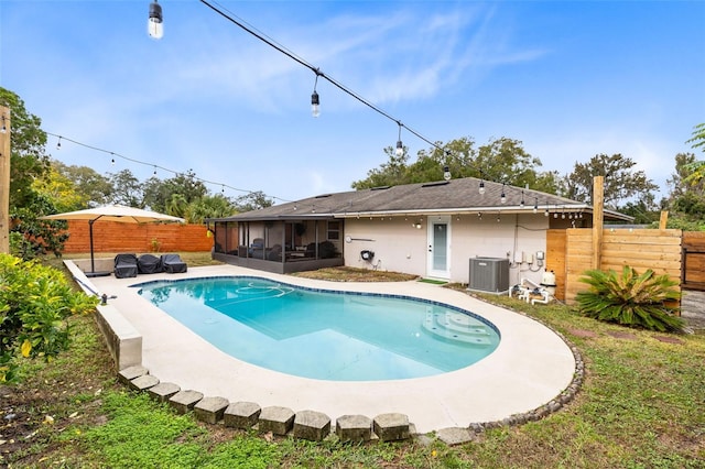 view of pool with cooling unit and a sunroom