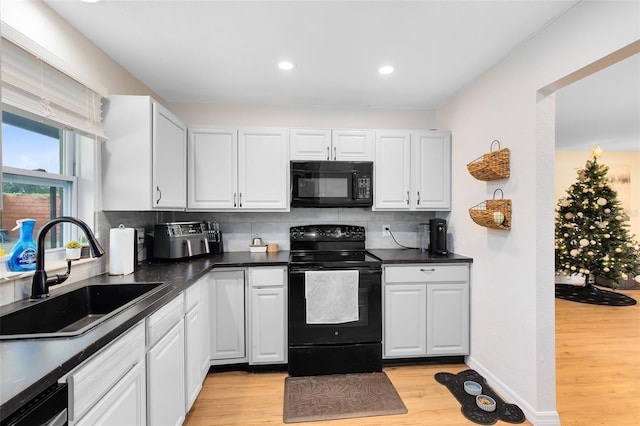 kitchen featuring black appliances, backsplash, white cabinets, and sink