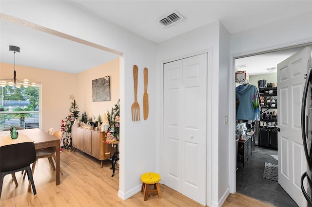 hallway with a chandelier and hardwood / wood-style floors