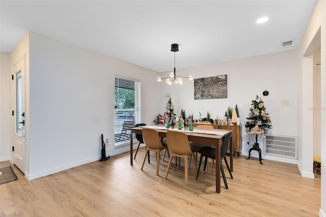 dining area featuring light hardwood / wood-style flooring and a notable chandelier