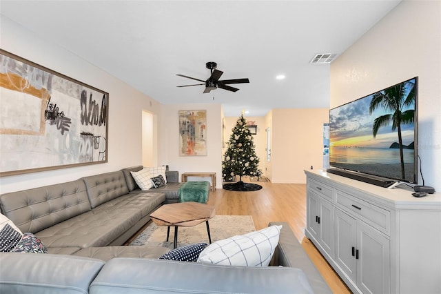 living room with light wood-type flooring and ceiling fan