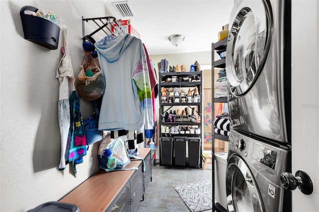 washroom featuring stacked washer and clothes dryer