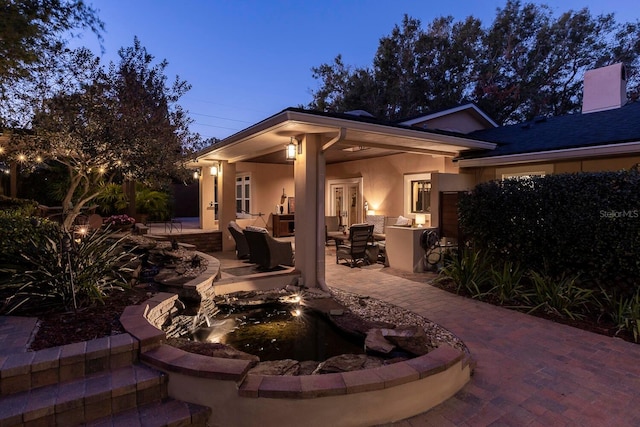 patio terrace at dusk featuring an outdoor living space