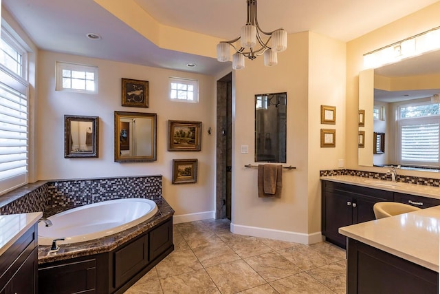 bathroom with tile patterned floors, a healthy amount of sunlight, vanity, and a chandelier