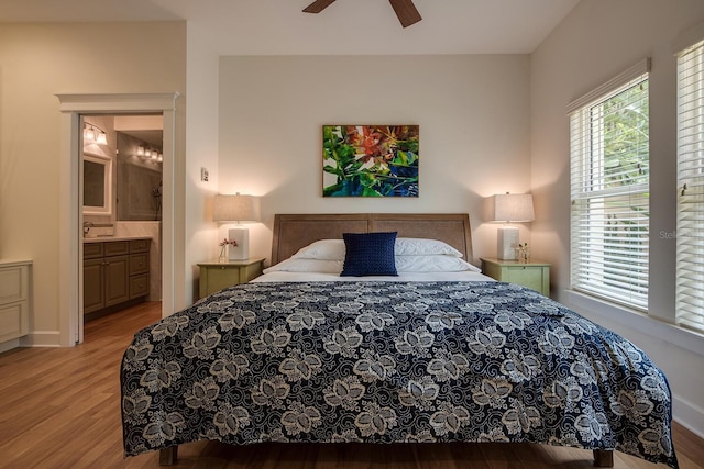 bedroom with ensuite bath, ceiling fan, and light wood-type flooring