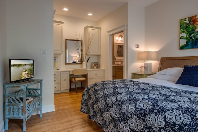 bedroom featuring connected bathroom and light wood-type flooring