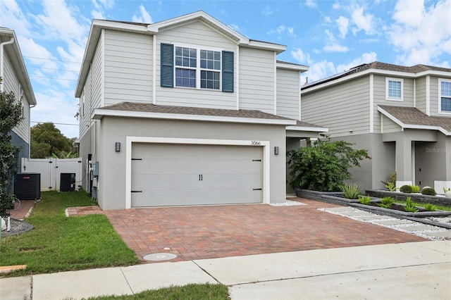 view of front facade with a garage and central AC