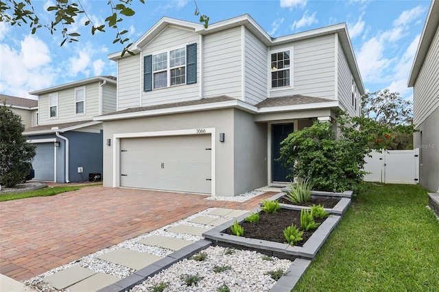 view of property featuring a front yard and a garage