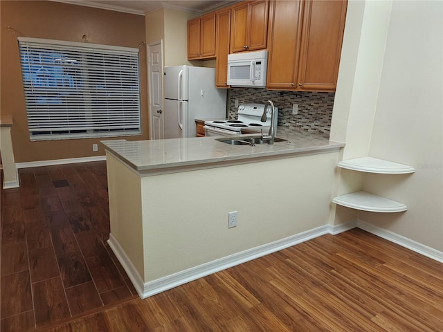 kitchen with dark hardwood / wood-style floors, backsplash, kitchen peninsula, white appliances, and ornamental molding