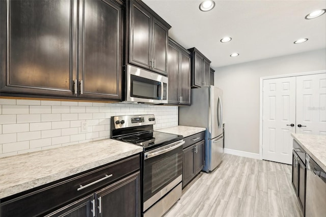 kitchen featuring dark brown cabinets, light hardwood / wood-style floors, decorative backsplash, and stainless steel appliances