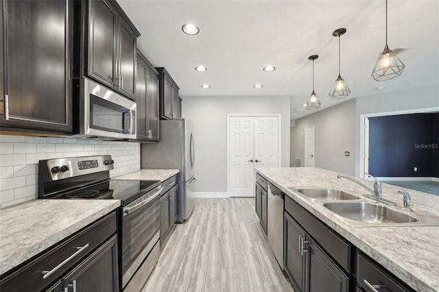 kitchen featuring sink, hanging light fixtures, stainless steel appliances, tasteful backsplash, and dark brown cabinets