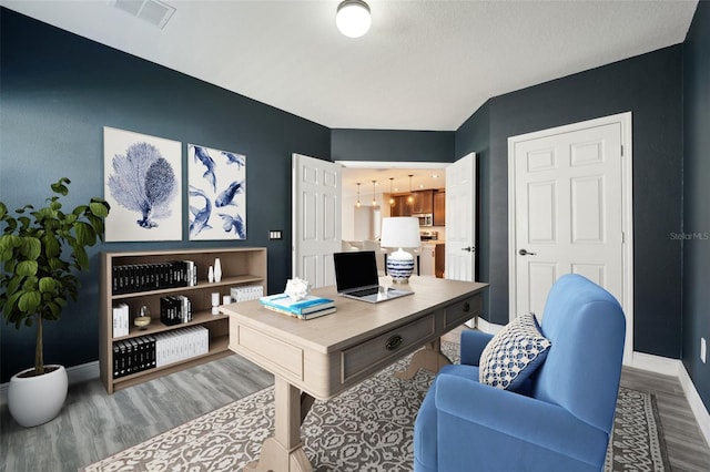 home office with hardwood / wood-style floors and washer / clothes dryer