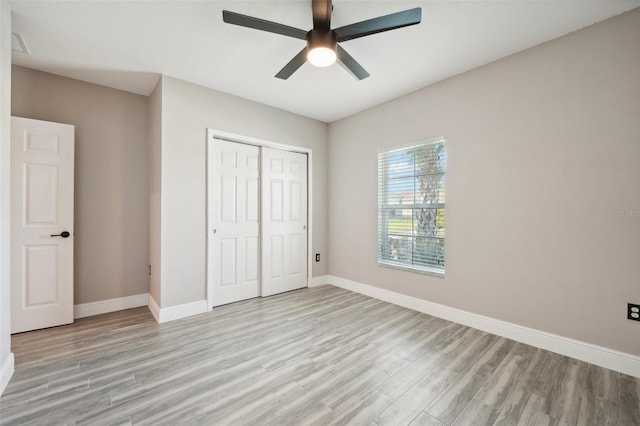 unfurnished bedroom with ceiling fan, a closet, and light wood-type flooring