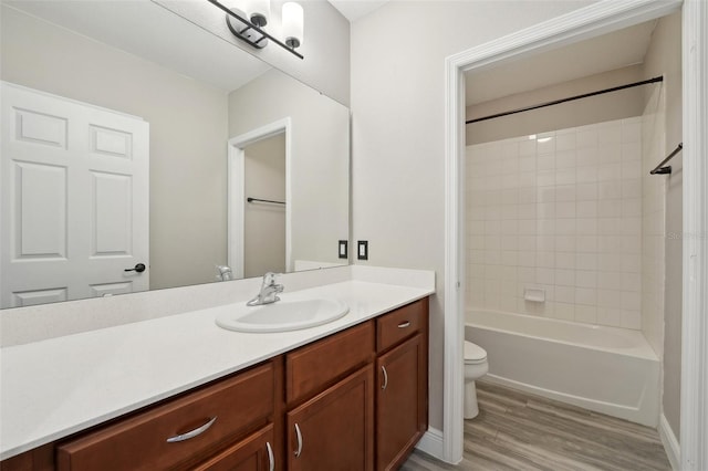 full bathroom featuring vanity, toilet, wood-type flooring, and tiled shower / bath combo