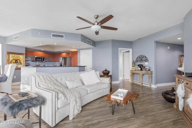 living room with ceiling fan and wood-type flooring