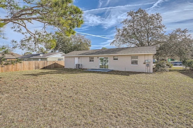 back of house featuring a yard and central AC unit