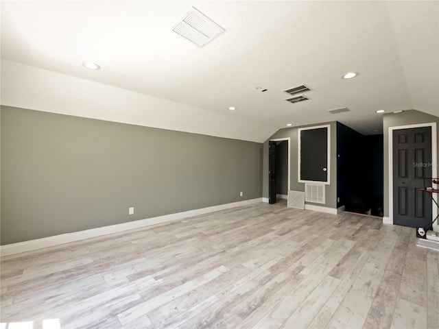 unfurnished living room featuring vaulted ceiling and light wood-type flooring